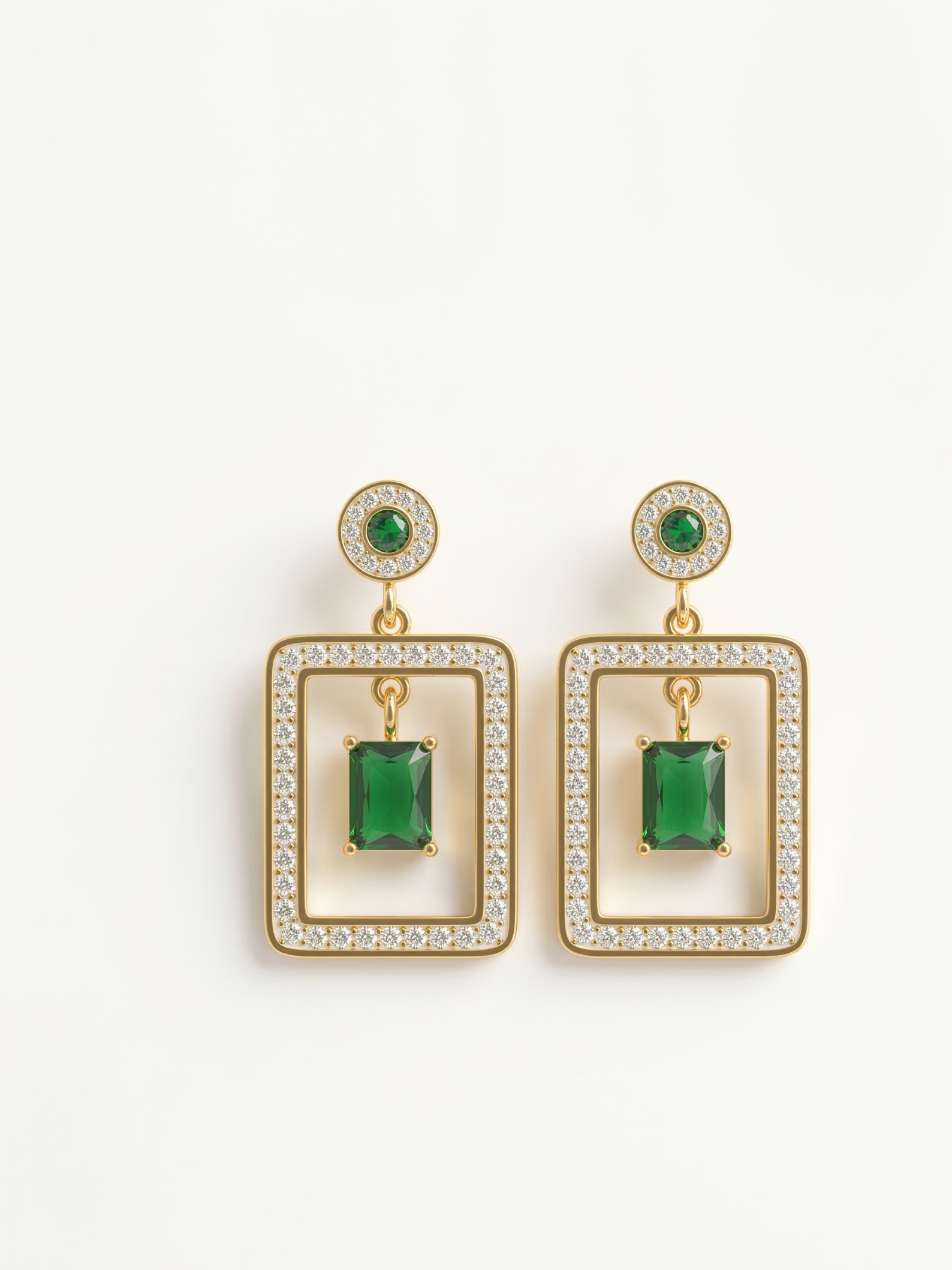 Pair of earrings with green gemstones and gold accents on a white background