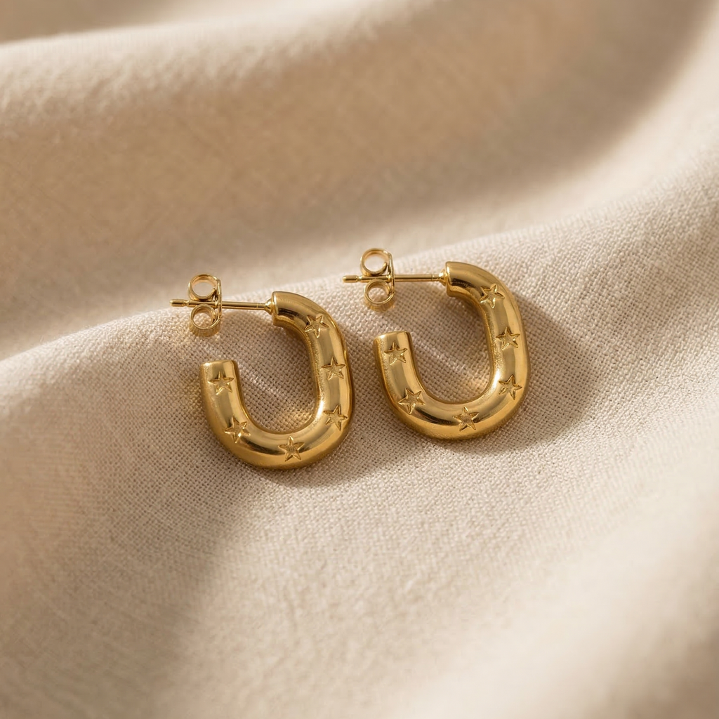 Gold hoop earrings on a beige fabric background