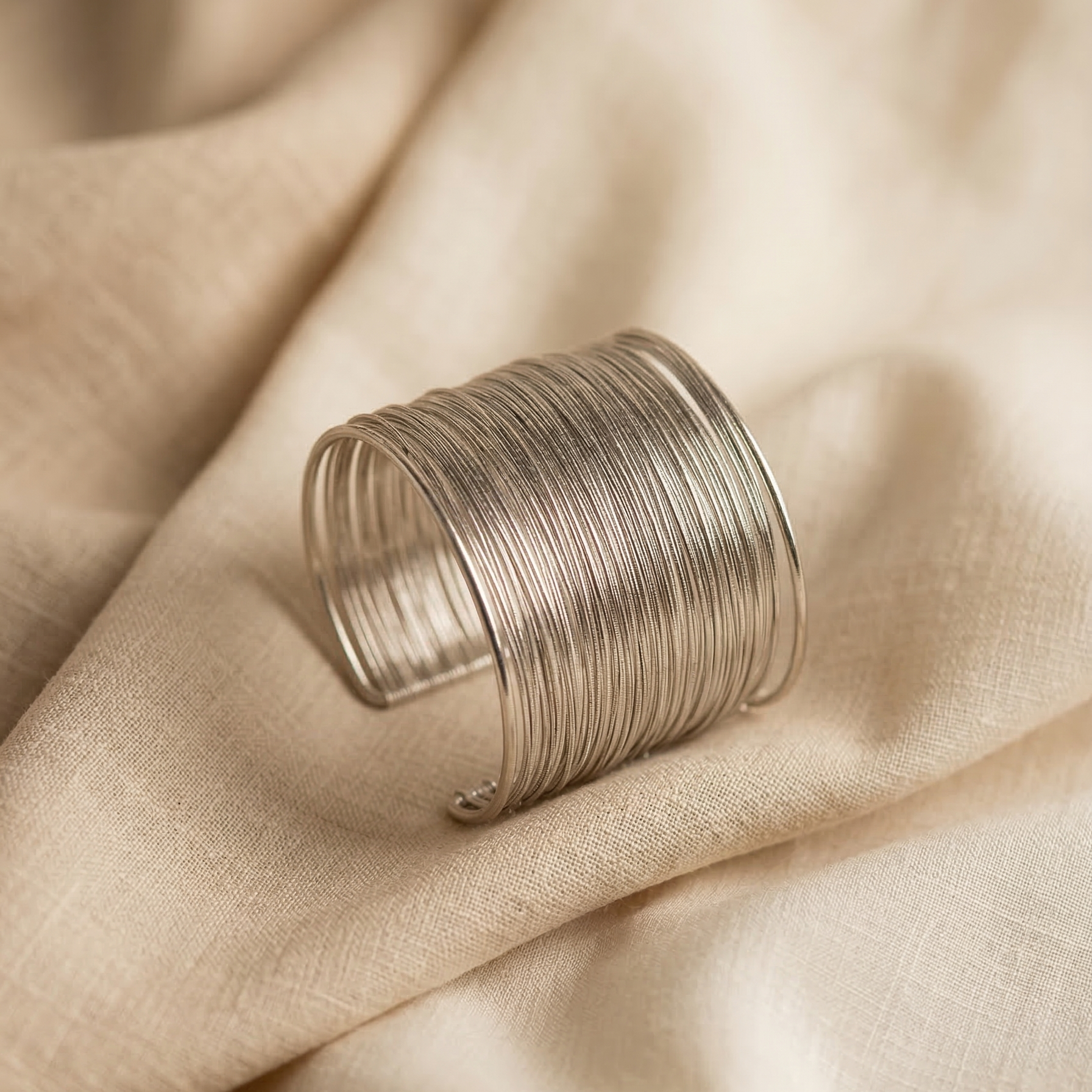 Silver ring on a beige fabric background