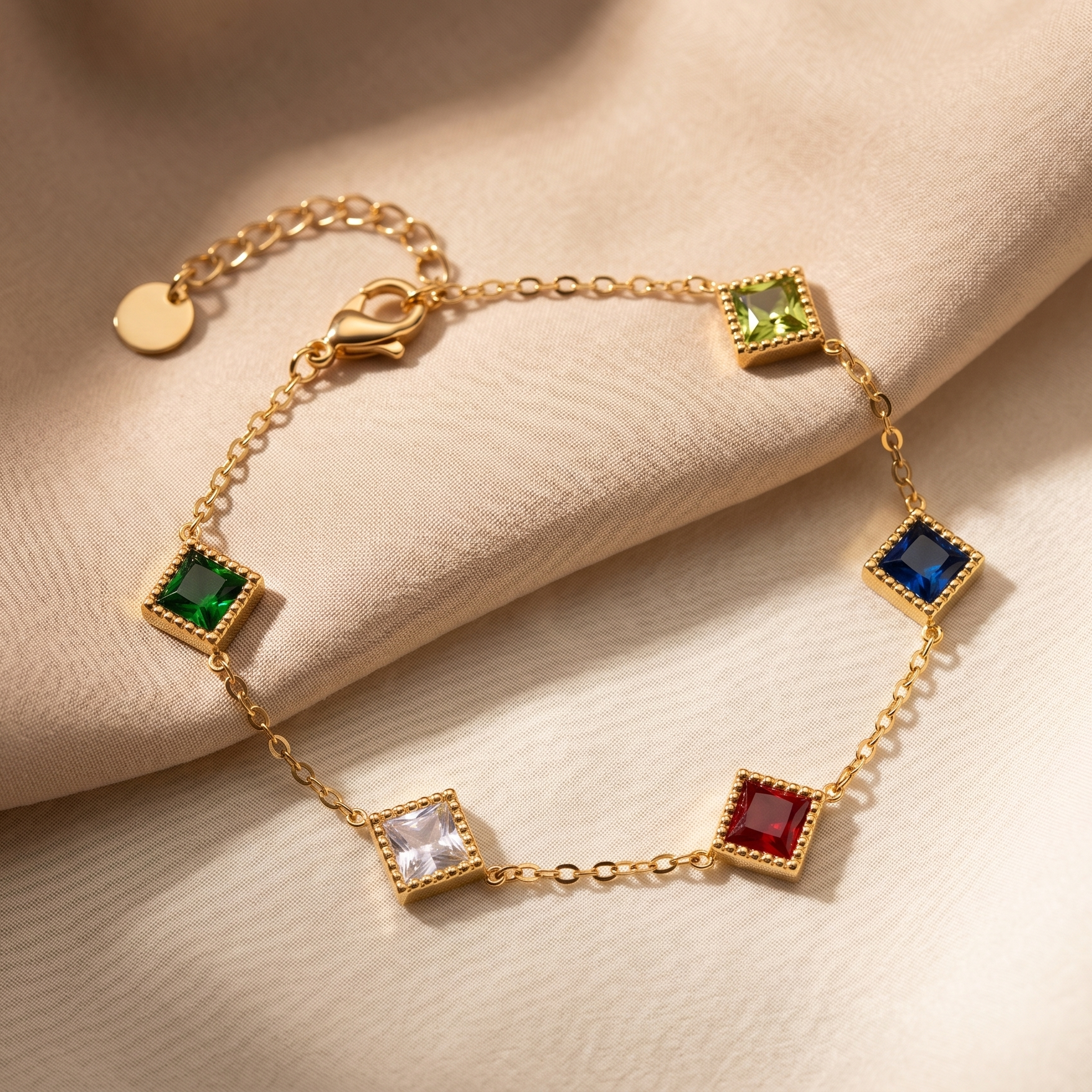 Gold bracelet with colorful gemstones on a beige fabric background