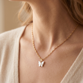 Butterfly necklace on a person wearing a light-colored top