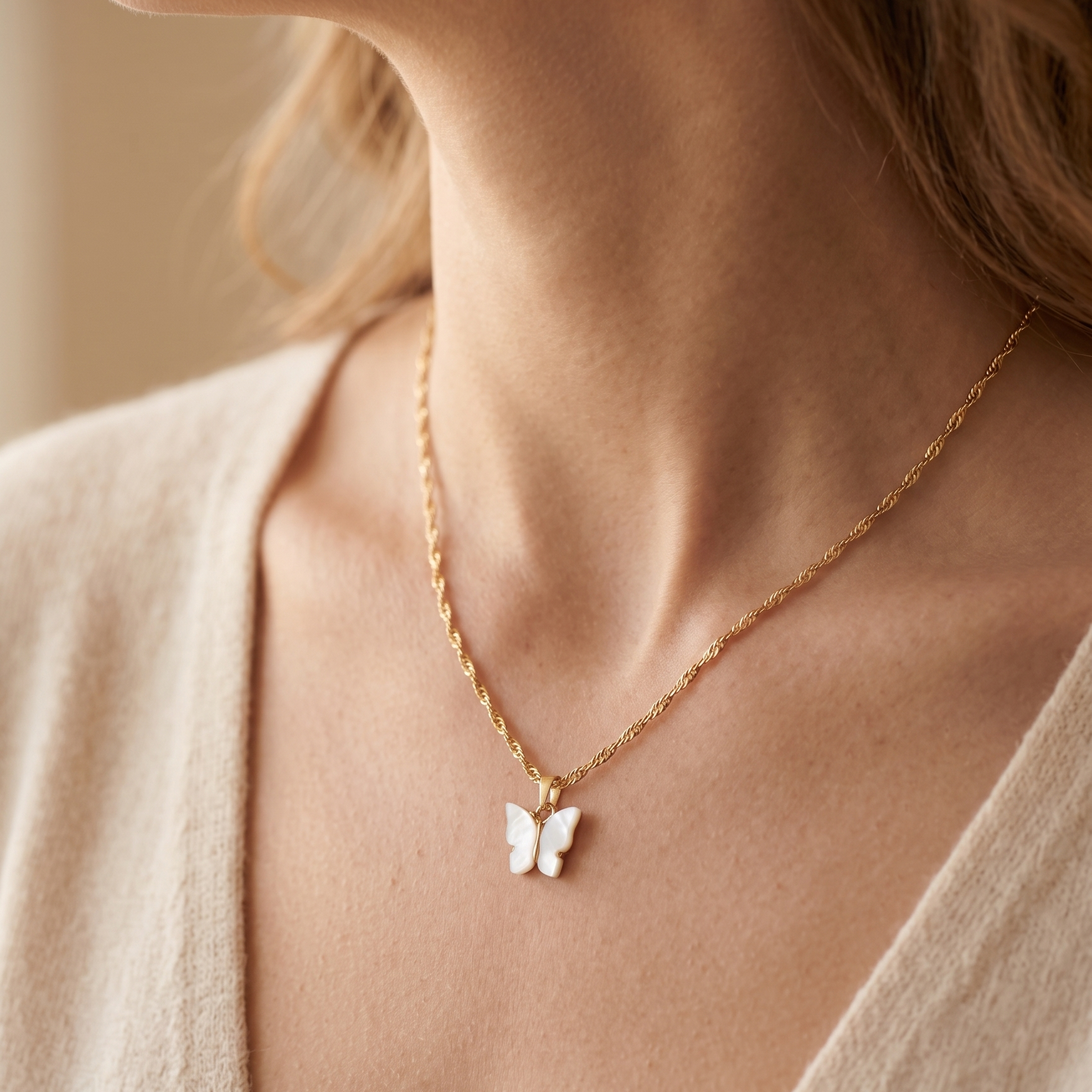 Butterfly necklace on a person wearing a light-colored top