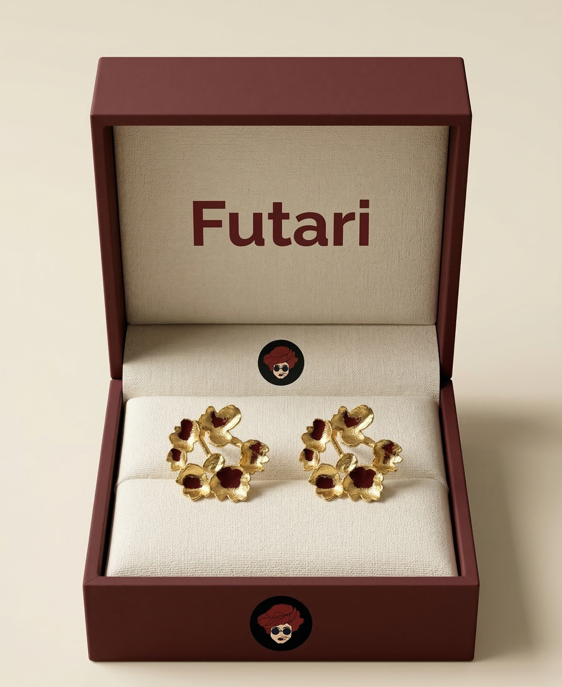 Gold earrings with red stones in a 'Futari' jewelry box on a beige background