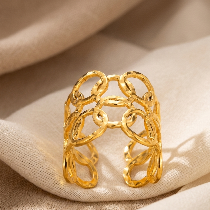 Gold chain ring on a beige fabric background