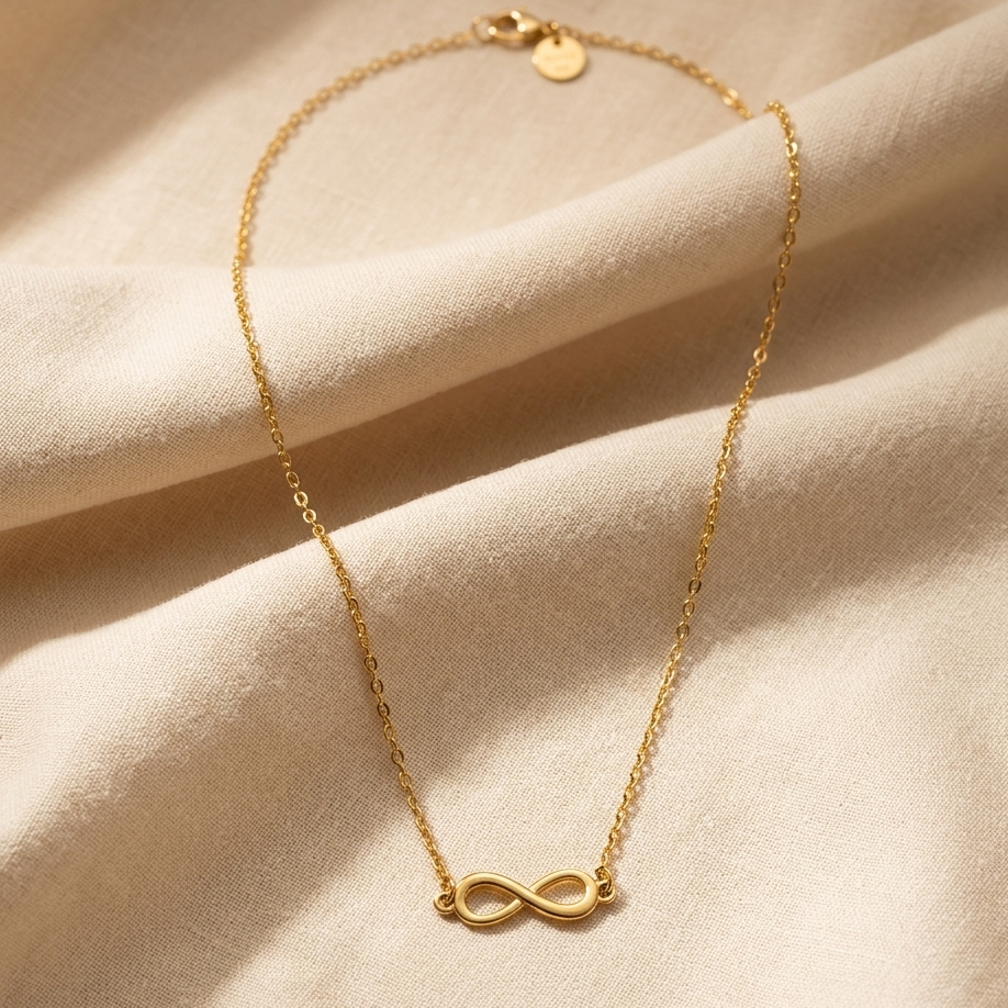 Gold bracelet with an infinity symbol on a beige fabric background