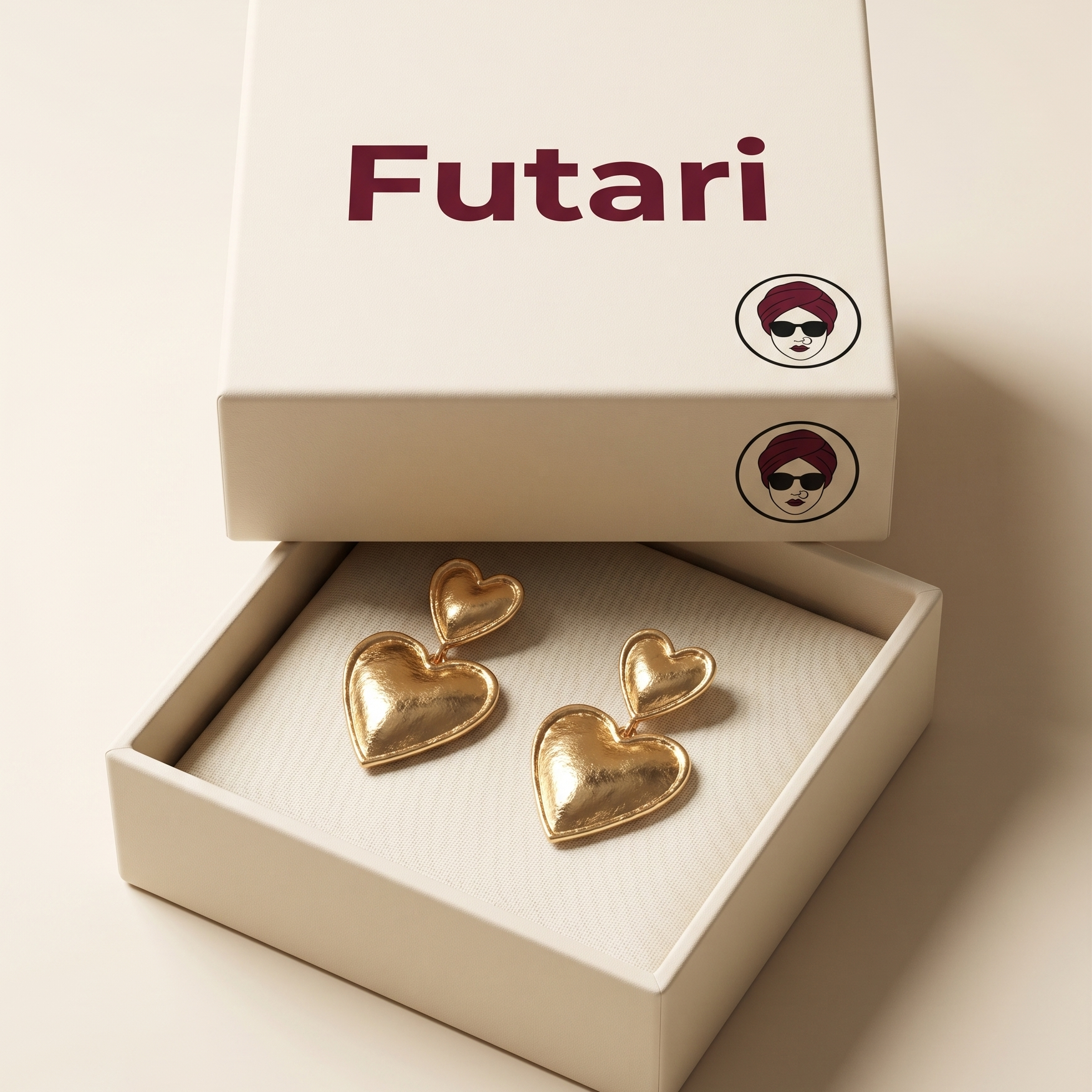 Gold heart-shaped earrings in a box with 'Futari' branding on a beige background