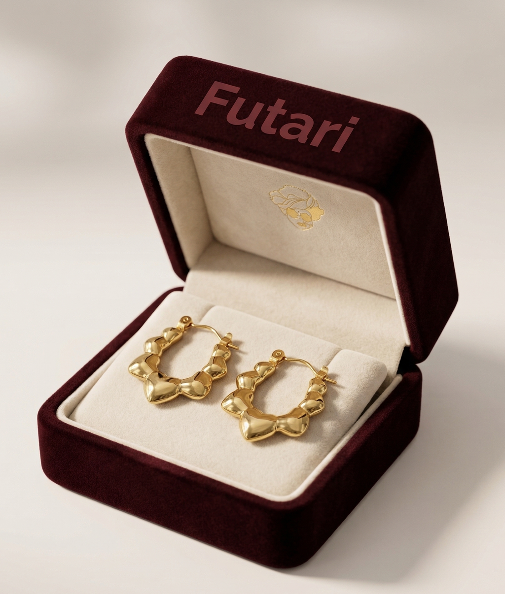 Gold hoop earrings in an open 'Futari' jewelry box on a light background
