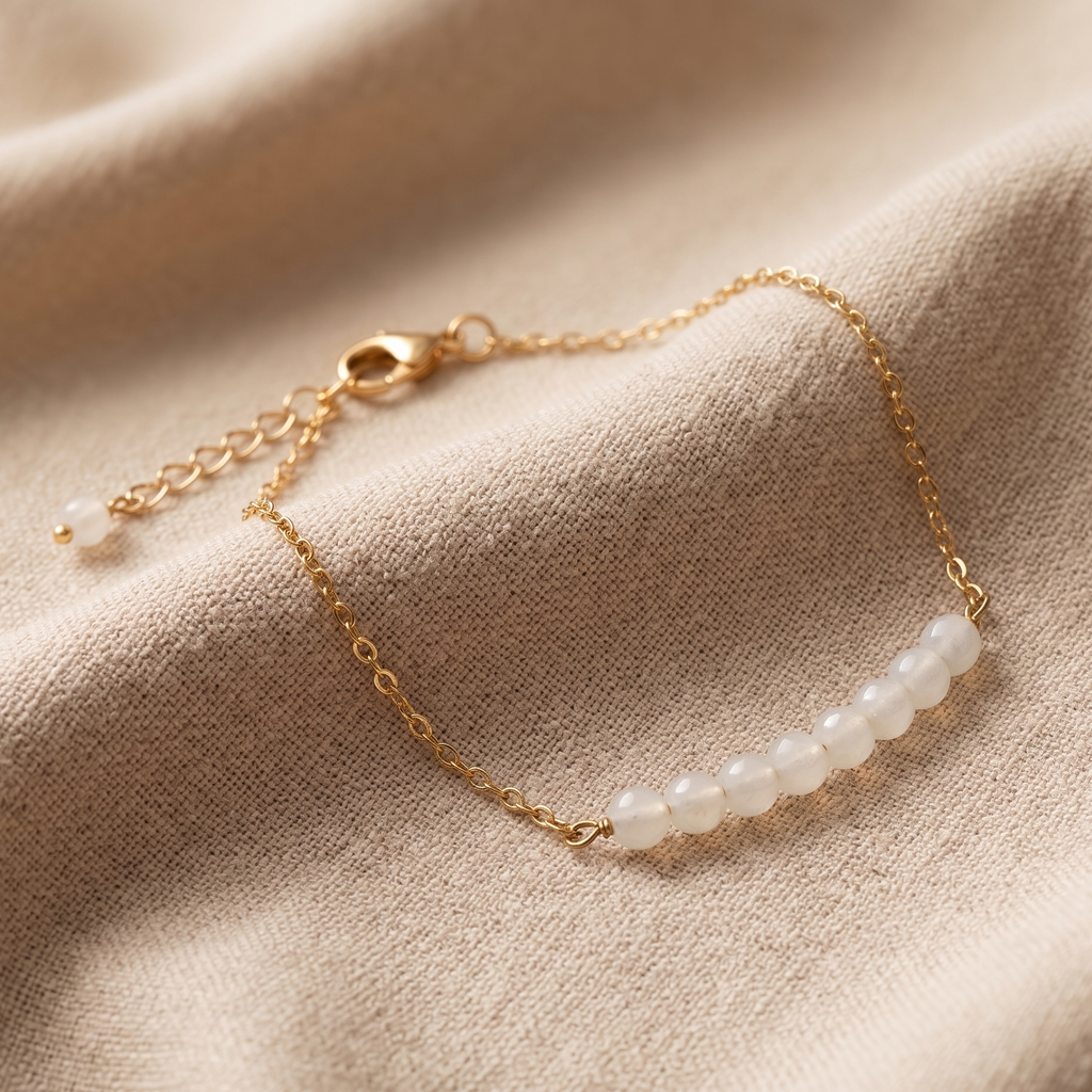 Gold bracelet with pearls on a beige fabric background