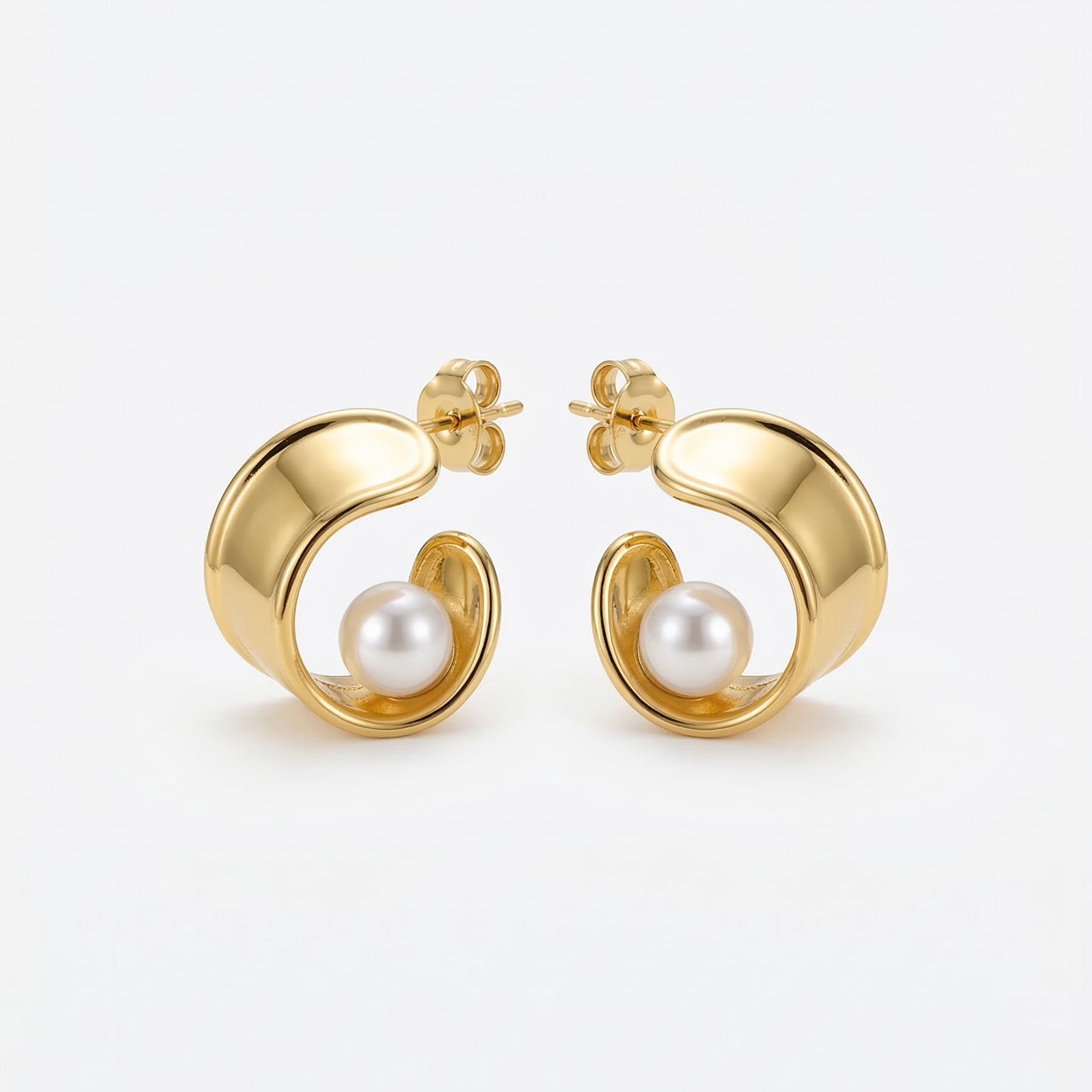 Gold hoop earrings with pearl centers on a white background