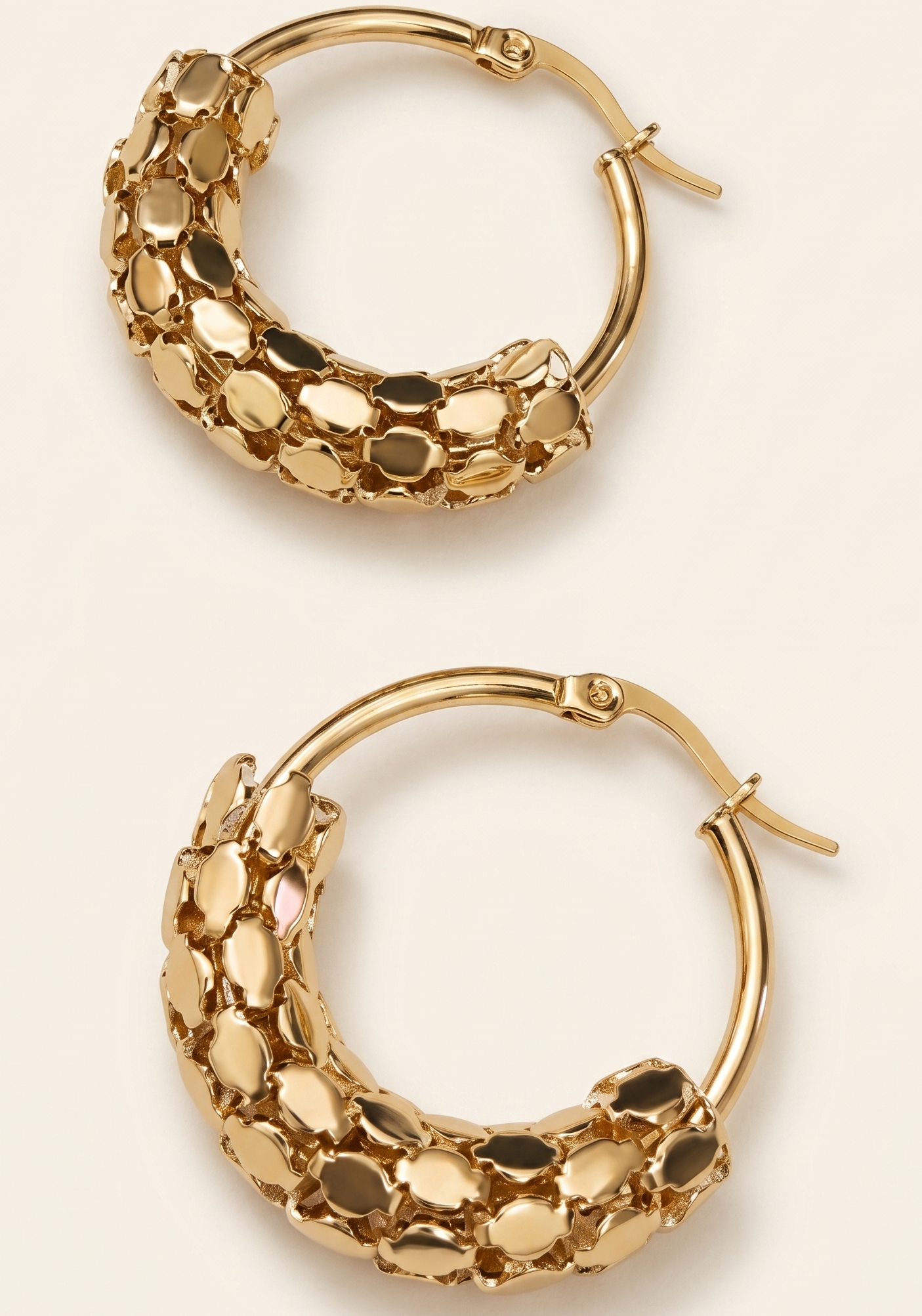 Pair of gold hoop earrings on a beige background