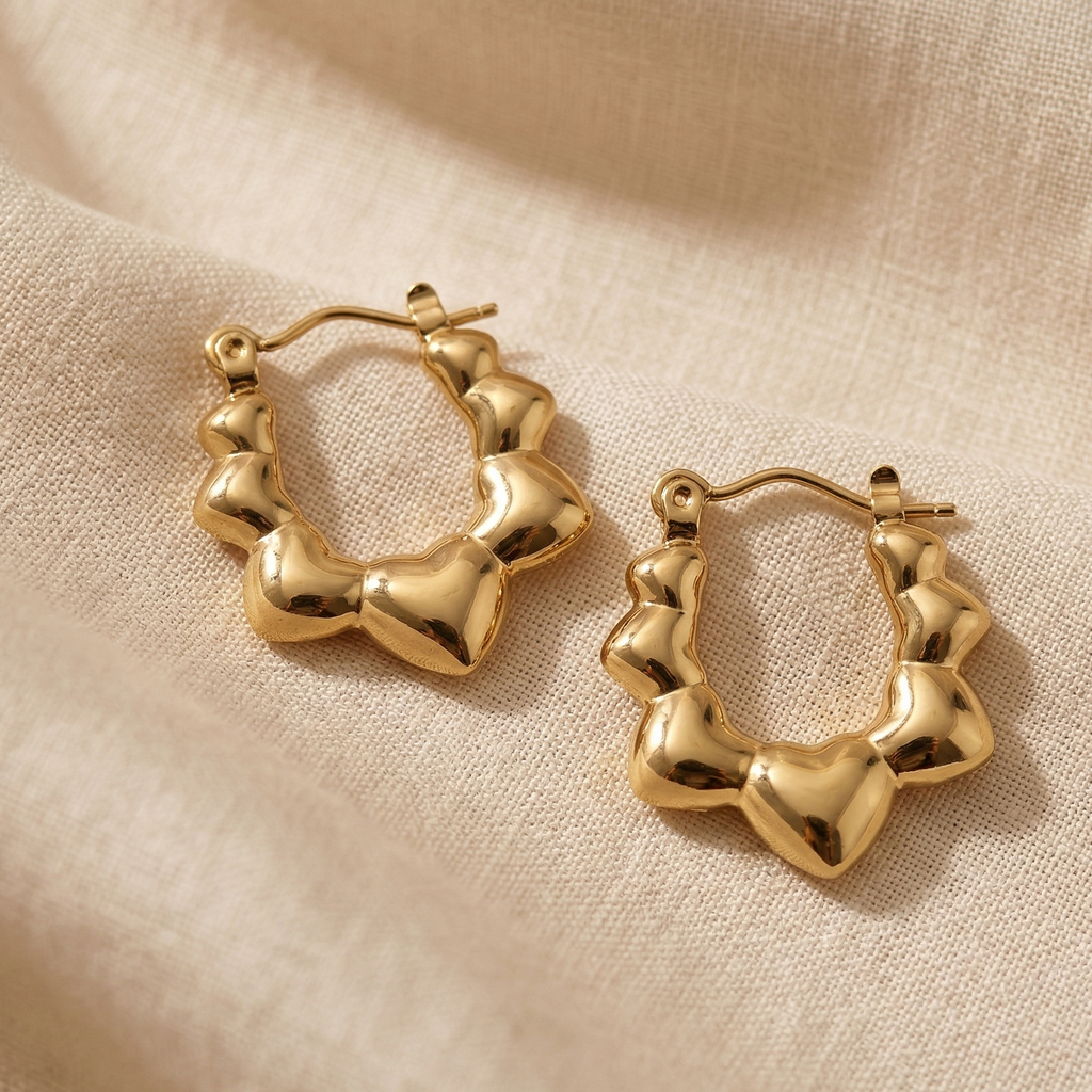 Gold hoop earrings on a beige fabric background