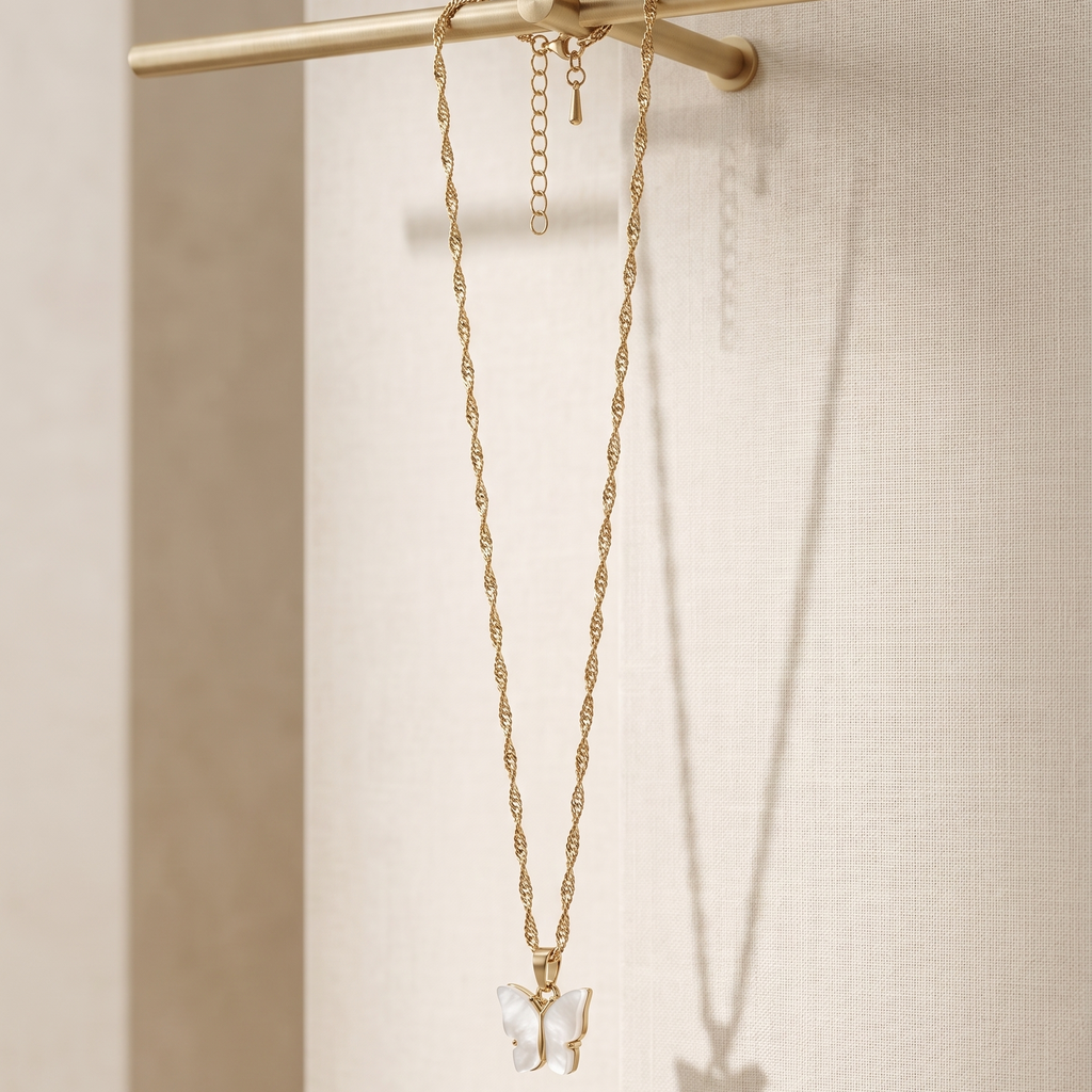 Gold necklace with a butterfly pendant on a beige background