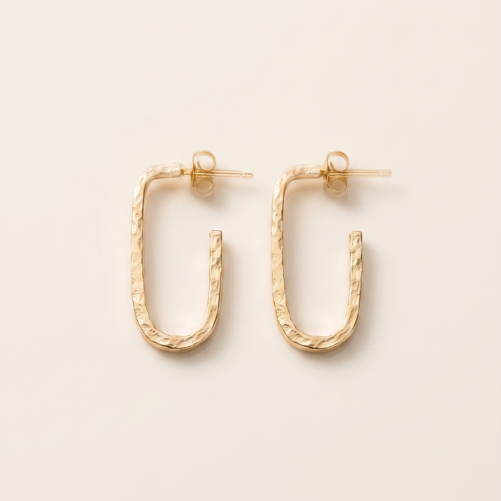 Gold hoop earrings on a beige background