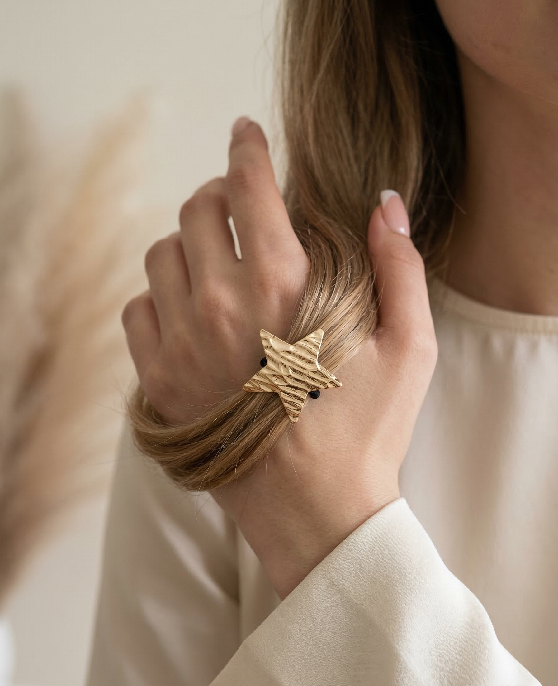 Person wearing a gold bracelet with a blurred background