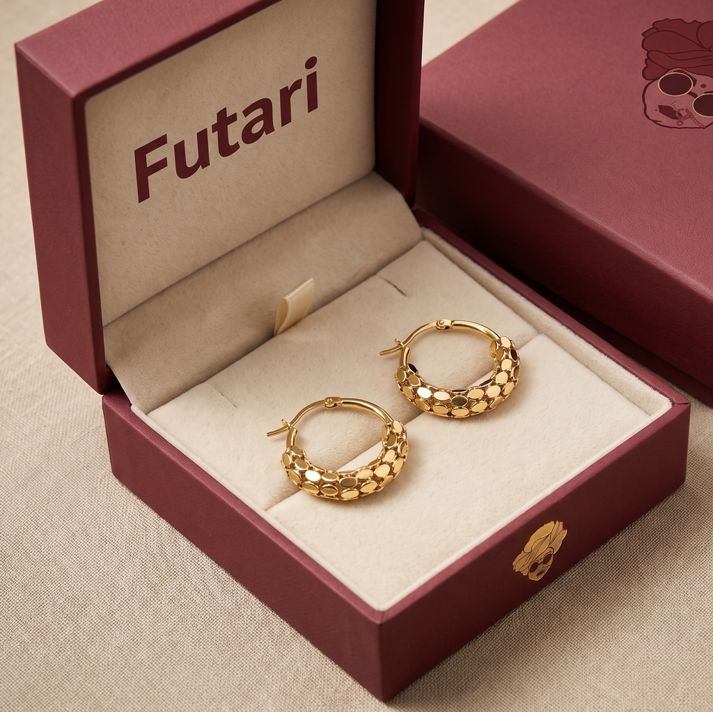 Gold hoop earrings in an open red 'Futari' jewelry box on a beige surface.