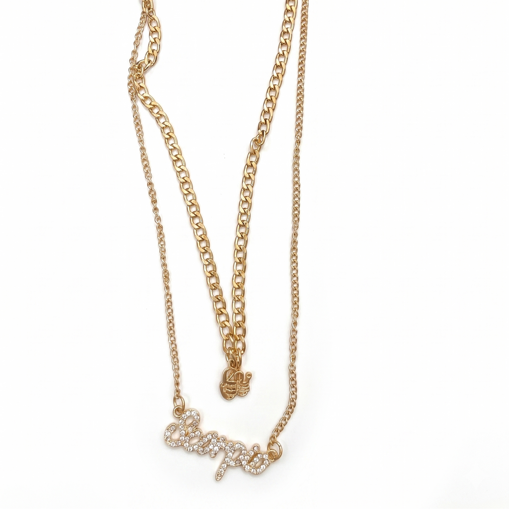 Gold chain necklace with a bow pendant on a white background