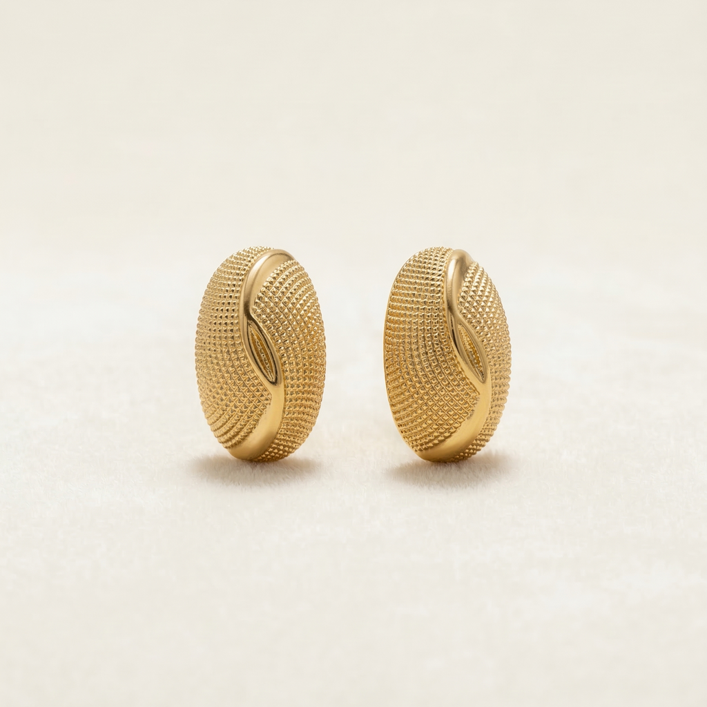 Pair of gold earrings on a light beige background