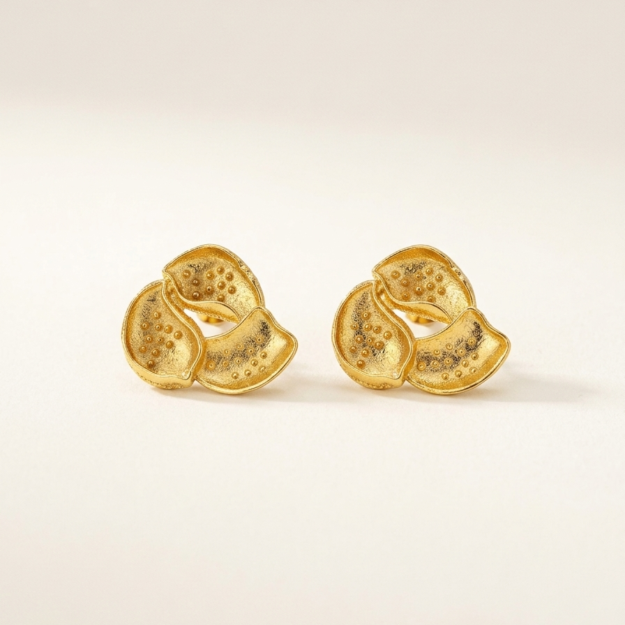 Pair of gold earrings on a light beige background