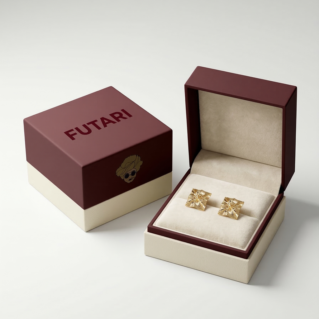 Gold earrings in an open jewelry box with 'FUTARI' branding on a light gray background