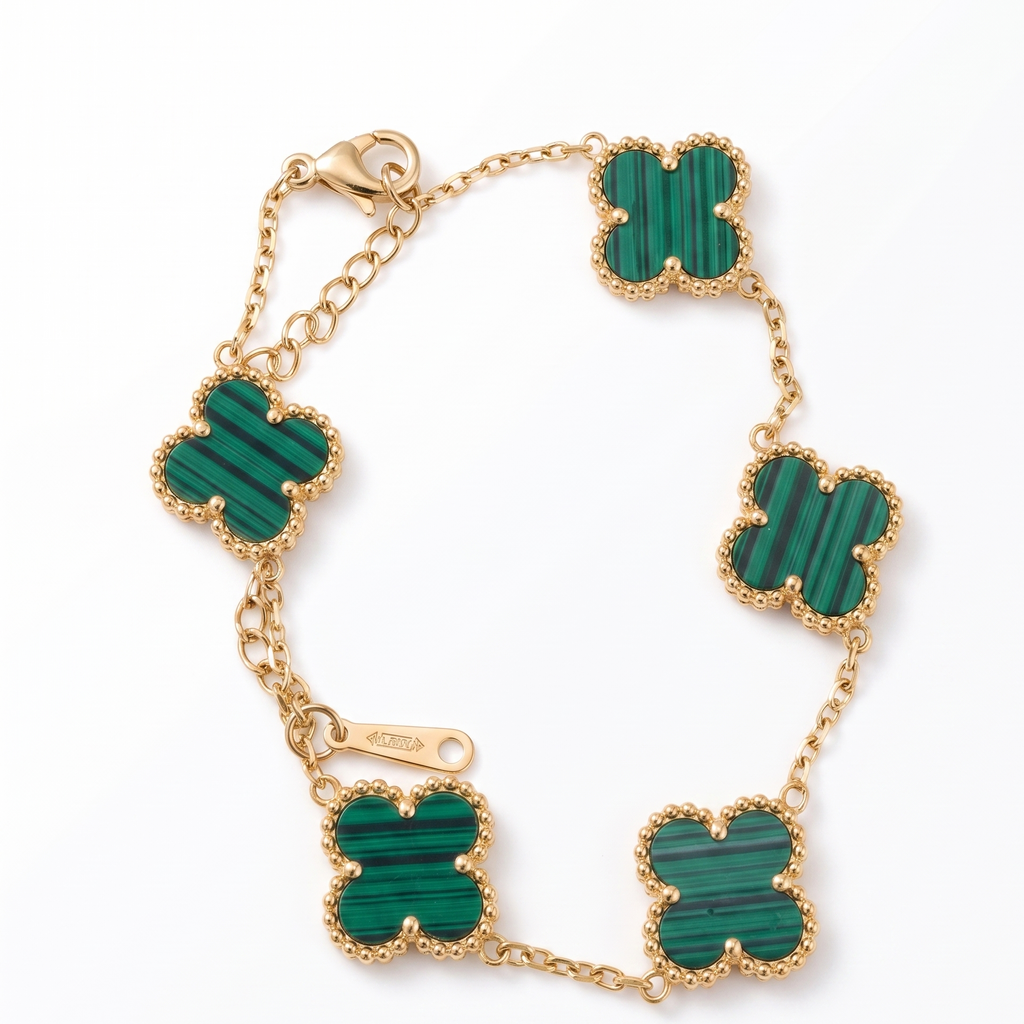 Gold bracelet with green stone accents on a white background