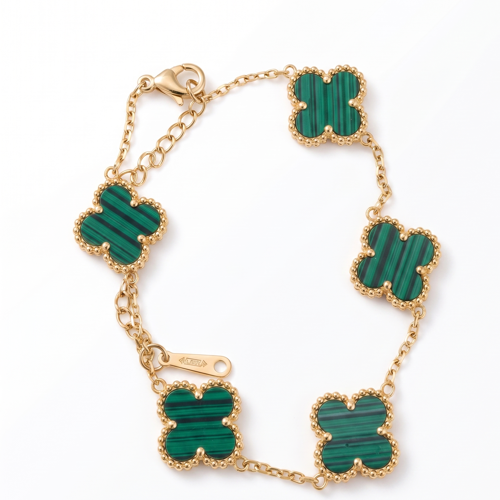 Gold bracelet with green stone accents on a white background
