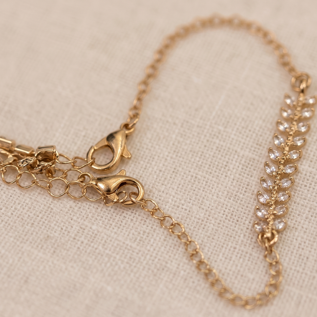 Gold bracelet with clear stones on a beige fabric background