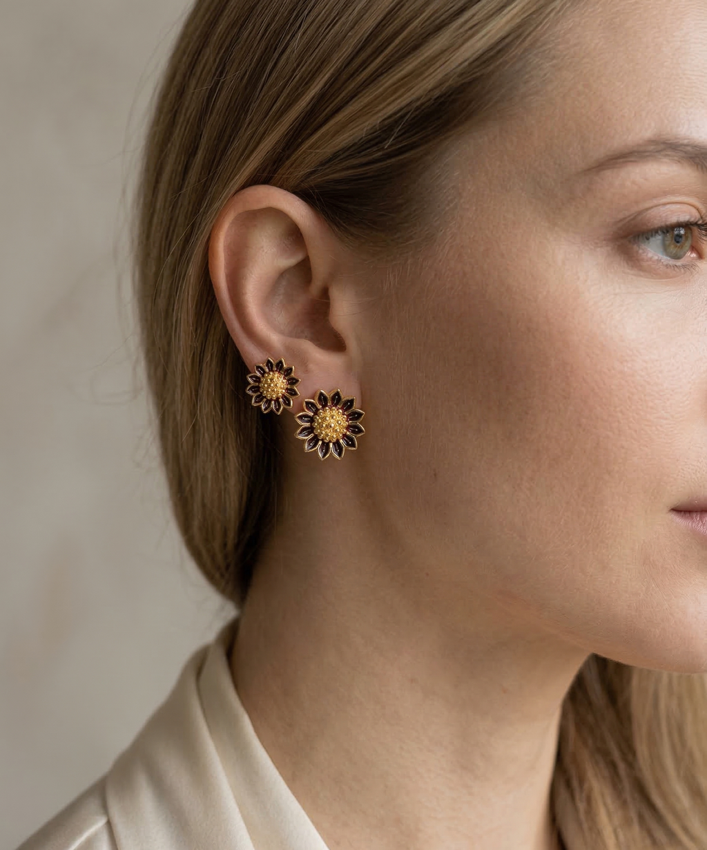 Close-up of a woman wearing a floral earring with a neutral background