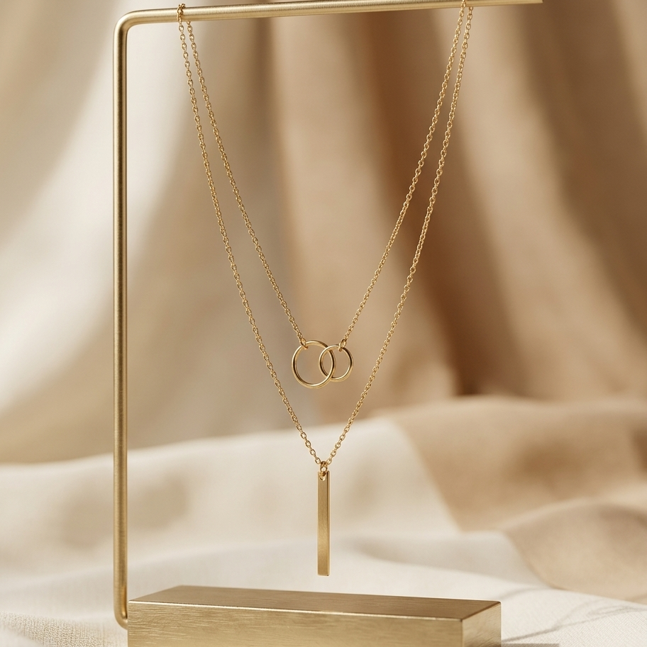 Gold necklace on a gold stand with a beige background