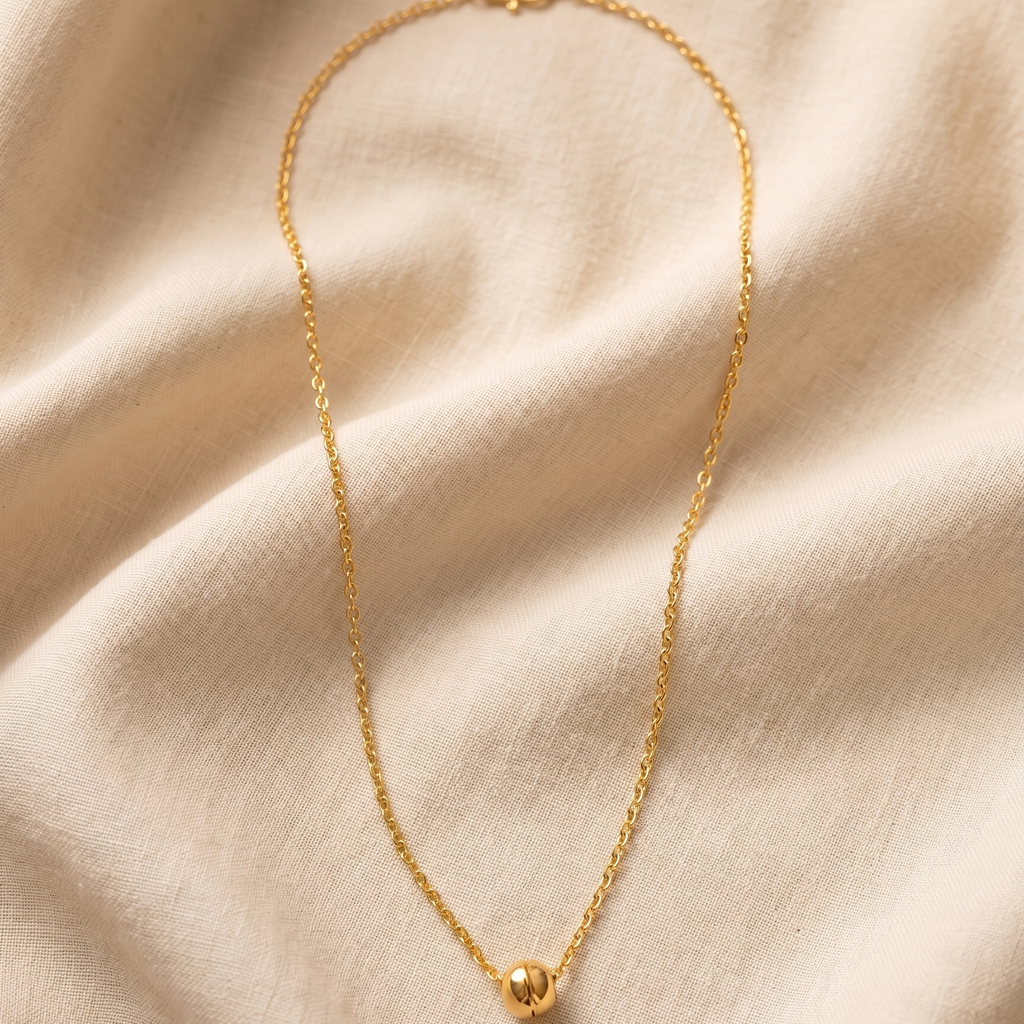 Gold necklace on a beige fabric background