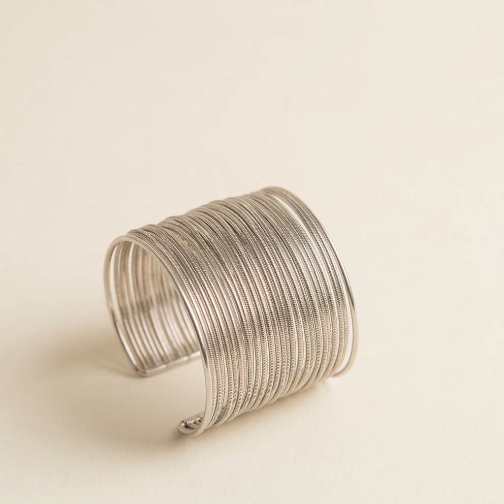 Silver wire cuff bracelet on a beige background
