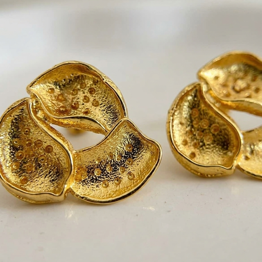 Pair of gold earrings on a white background