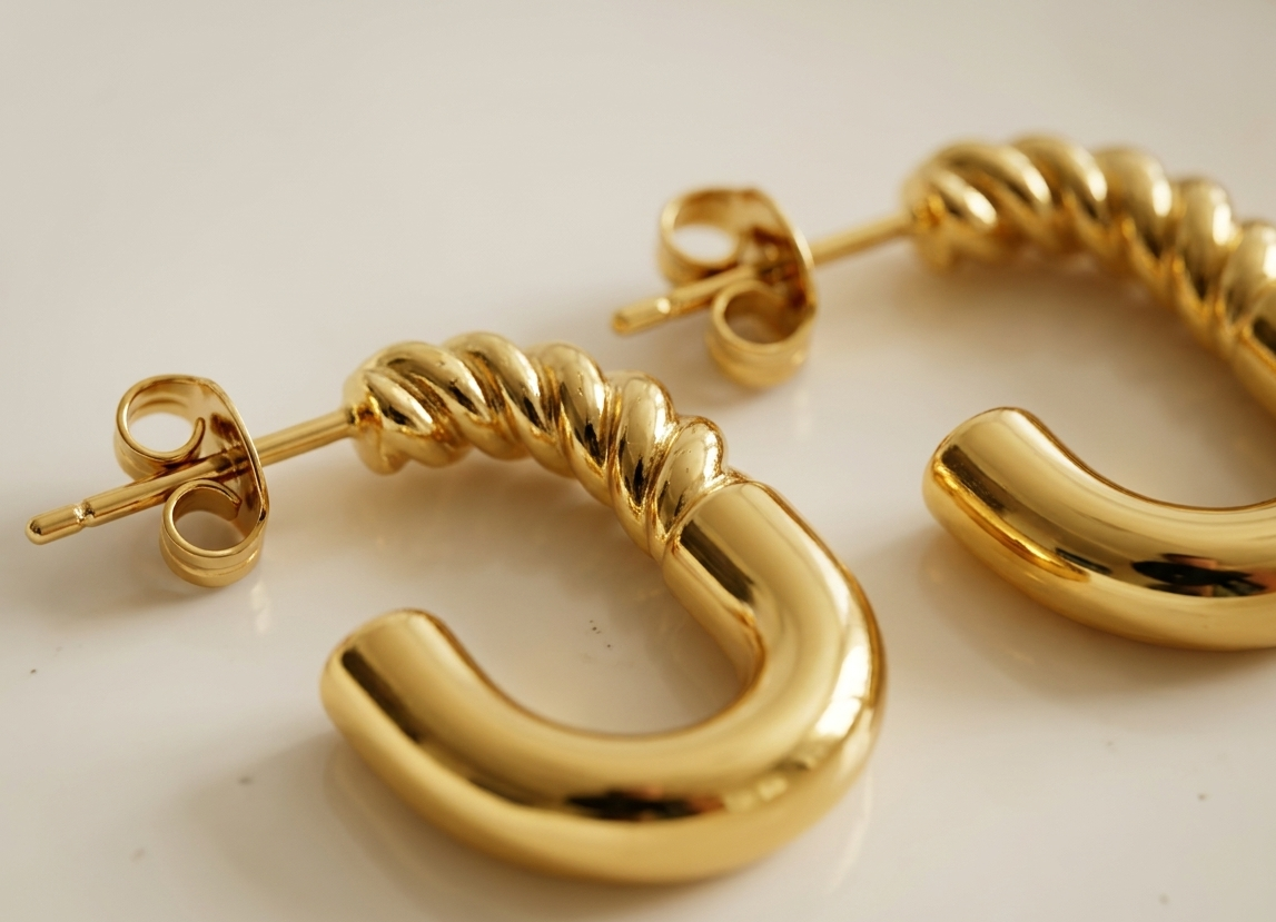 Gold hoop earrings on a light background