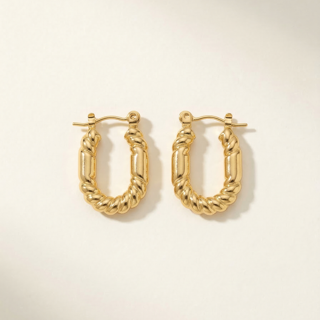 Gold hoop earrings on a light beige background