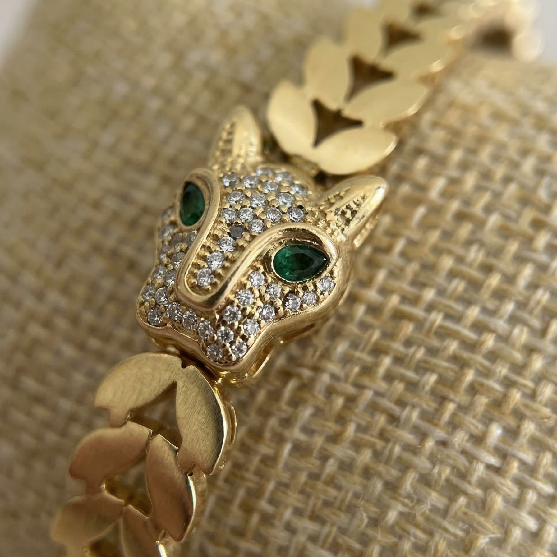 Gold bracelet with a fox head design on a textured beige background