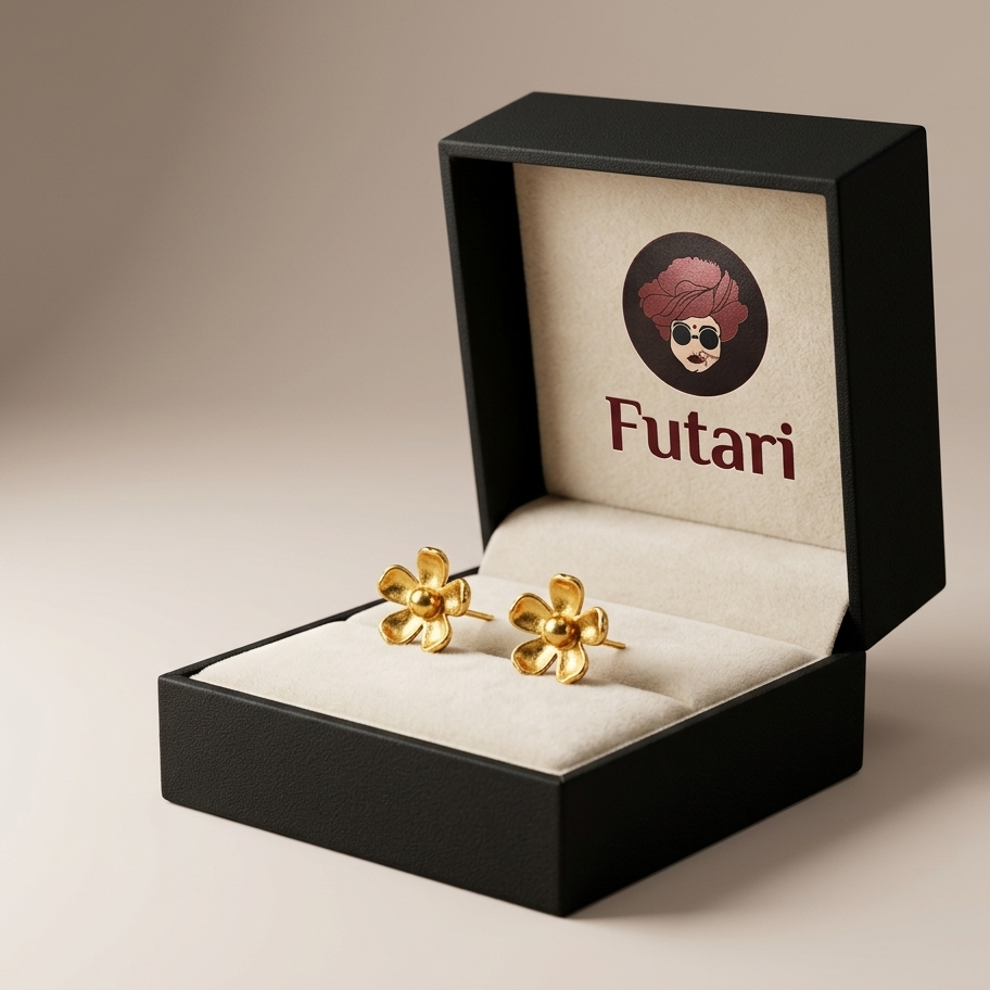 Gold earrings in a black box with 'Futari' branding on a beige background