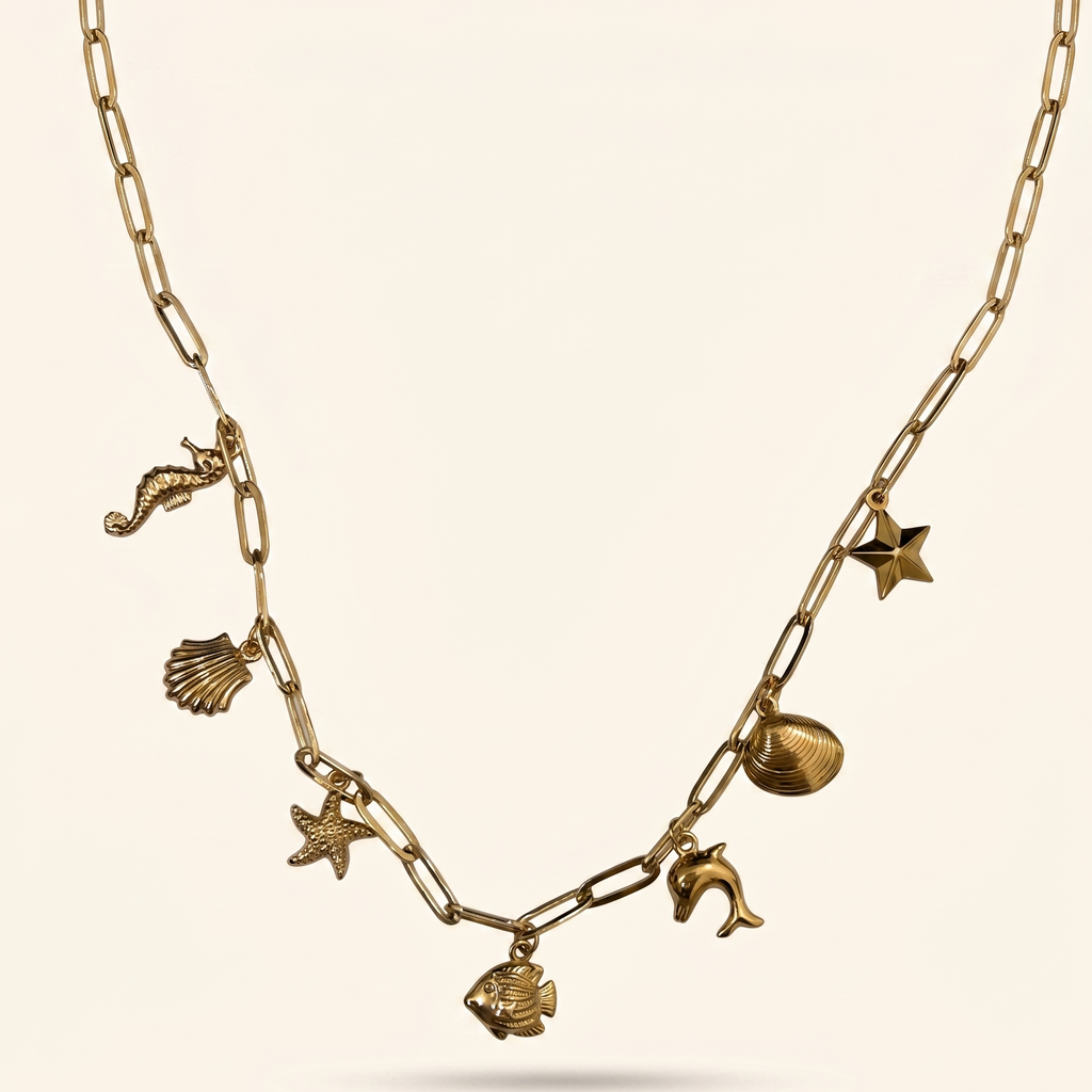 Gold necklace with various charms on a beige background