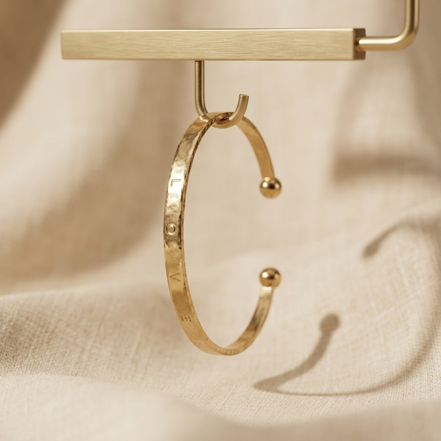 Gold hoop earring on a beige fabric background