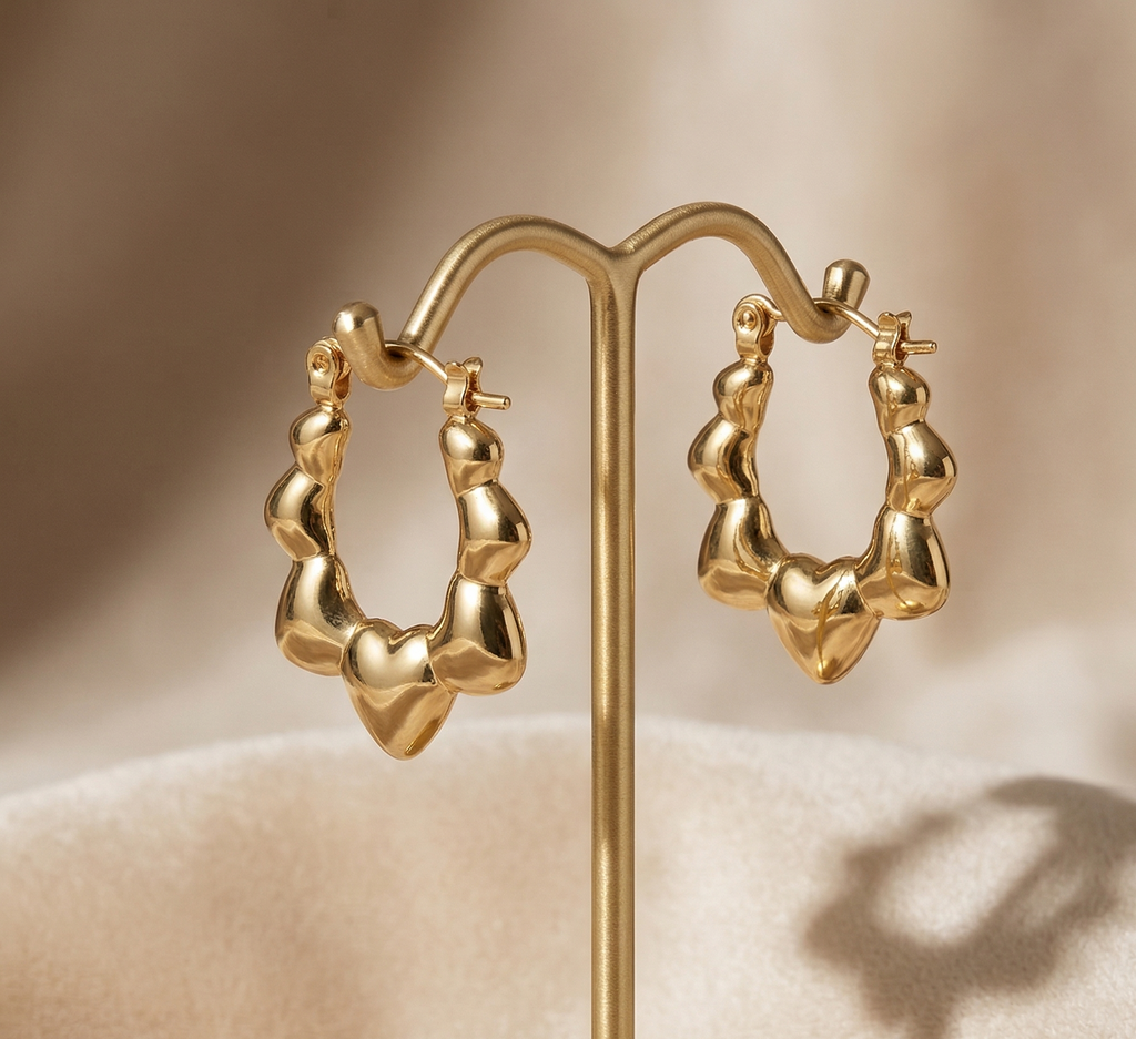 Gold hoop earrings on a stand with a beige background