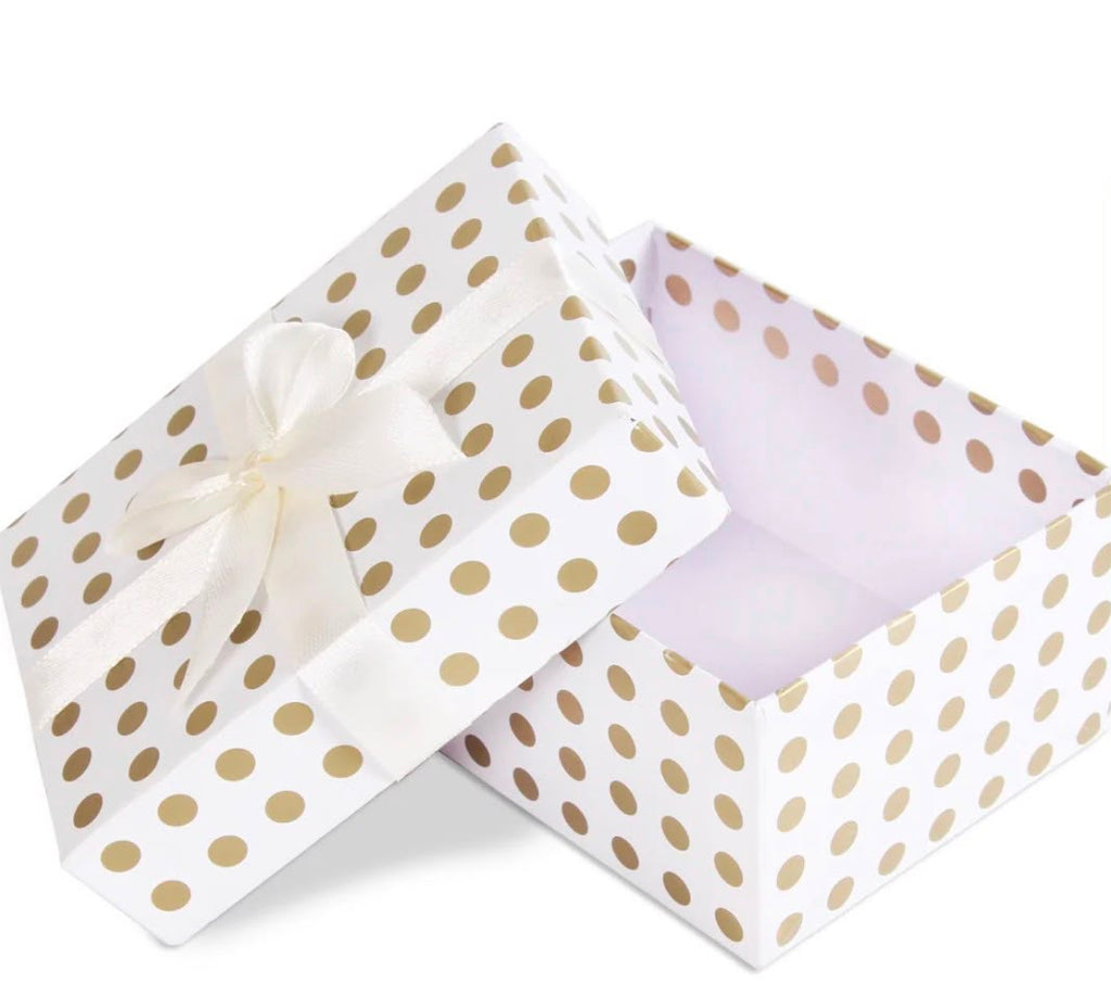 A square white gift box with gold polka dots, shown open with the lid leaning against the front. A white satin ribbon is tied around the box and bow.